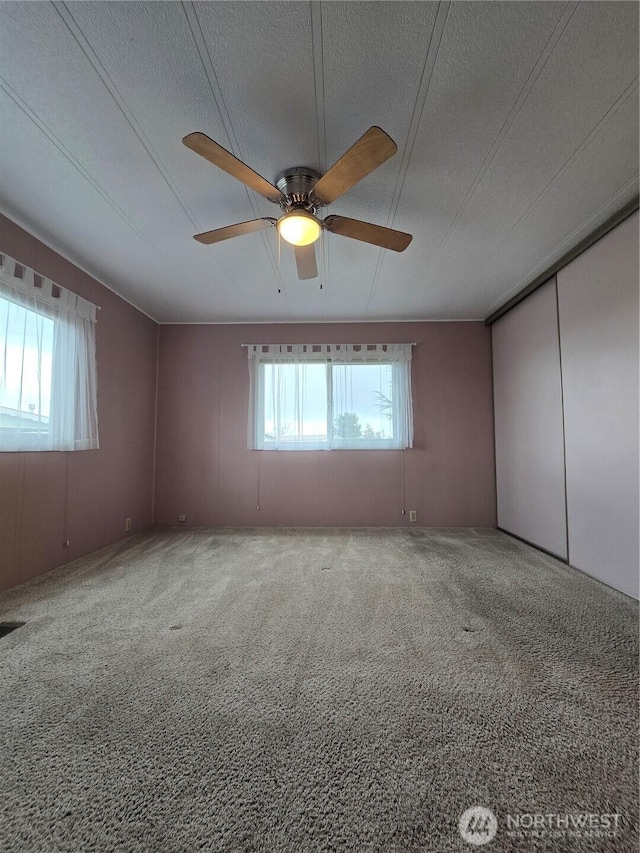 unfurnished bedroom with a ceiling fan, carpet, a closet, and a textured ceiling