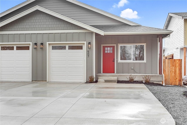 view of front facade featuring driveway, roof with shingles, a garage, and fence