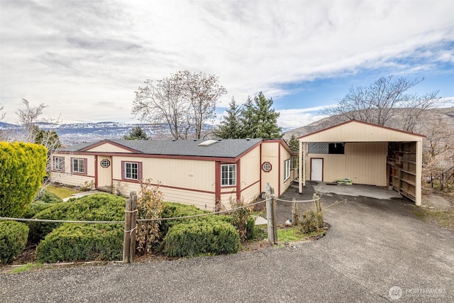 view of front of property featuring a carport, fence, and driveway