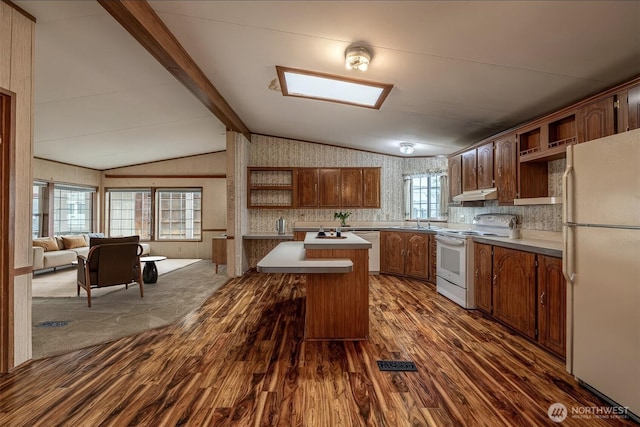 kitchen featuring white appliances, lofted ceiling with beams, open shelves, a sink, and under cabinet range hood