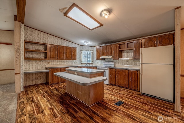 kitchen featuring vaulted ceiling, white appliances, wallpapered walls, and open shelves