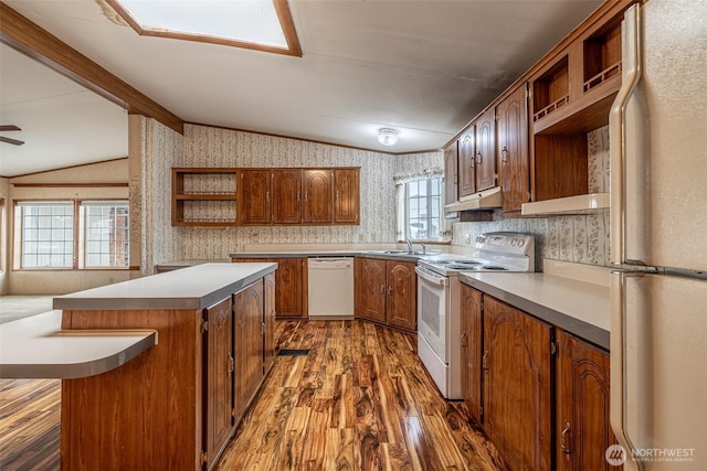 kitchen with open shelves, under cabinet range hood, white appliances, wallpapered walls, and vaulted ceiling with beams