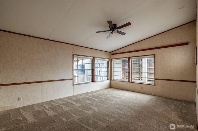 carpeted empty room with wallpapered walls, a ceiling fan, lofted ceiling, and ornamental molding