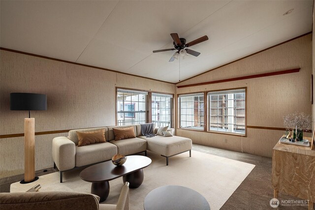 living room with wallpapered walls, lofted ceiling, carpet, and a ceiling fan