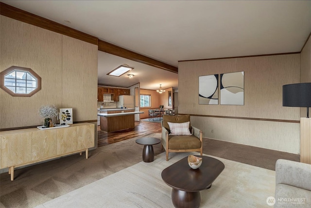 living room featuring lofted ceiling with beams, carpet, and wallpapered walls