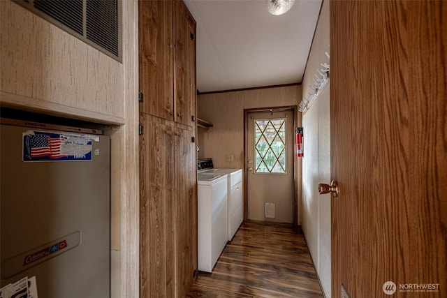 clothes washing area featuring laundry area, washing machine and dryer, crown molding, and dark wood-style flooring