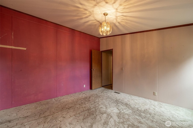 empty room with an inviting chandelier and crown molding