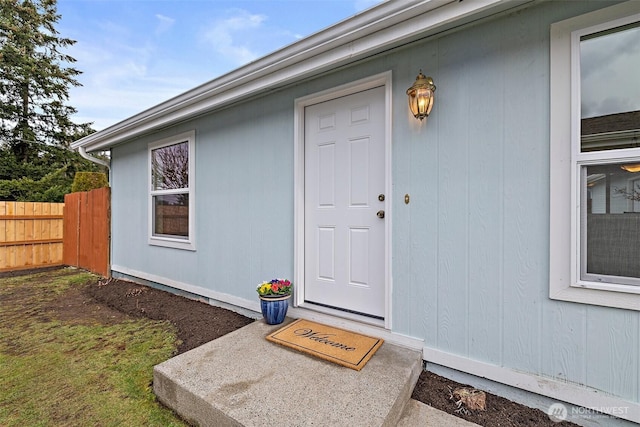 doorway to property featuring fence