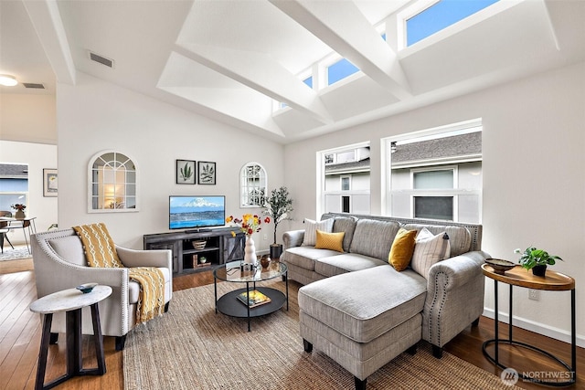 living area with visible vents, baseboards, high vaulted ceiling, and hardwood / wood-style flooring