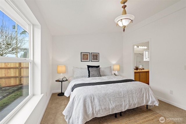 bedroom featuring connected bathroom, baseboards, and carpet