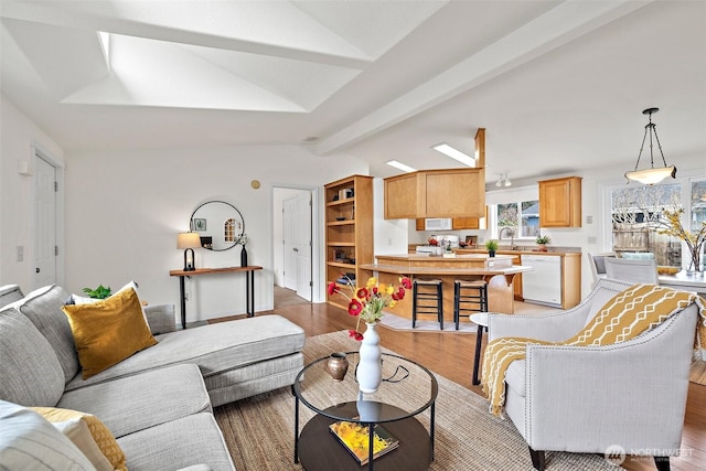 living room featuring light wood-style flooring, vaulted ceiling with beams, and ceiling fan