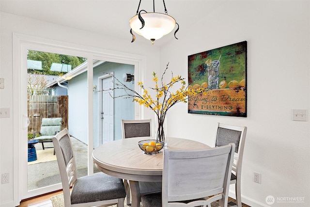 dining area with baseboards and wood finished floors