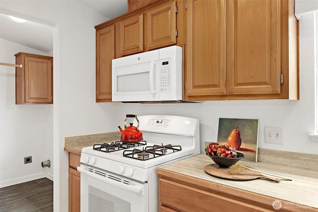 kitchen with dark wood finished floors, white appliances, light countertops, and baseboards