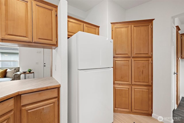 kitchen with light wood finished floors, light countertops, and freestanding refrigerator