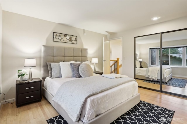 bedroom featuring a closet, recessed lighting, light wood-style flooring, and baseboards