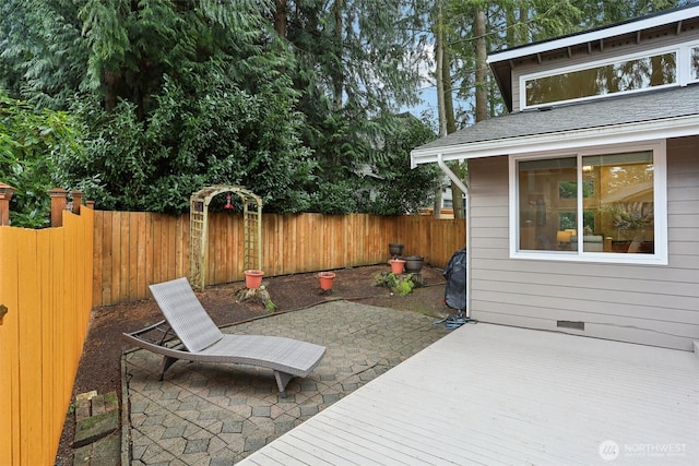 wooden terrace featuring a patio and a fenced backyard