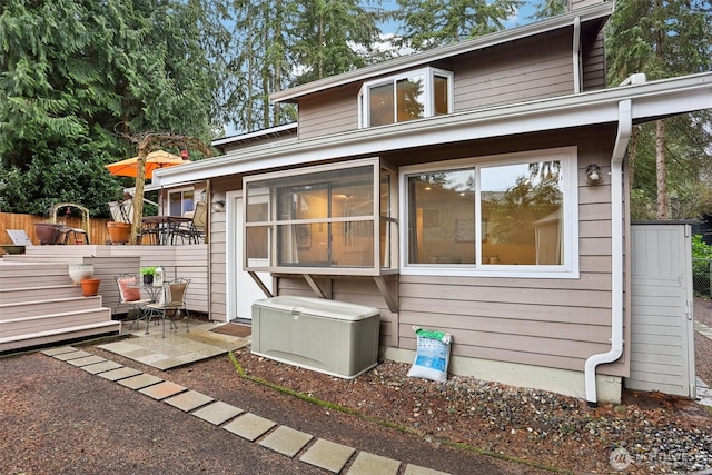 rear view of house with a deck and fence