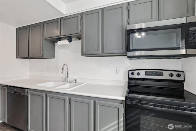 kitchen with a sink, light countertops, gray cabinetry, and stainless steel appliances