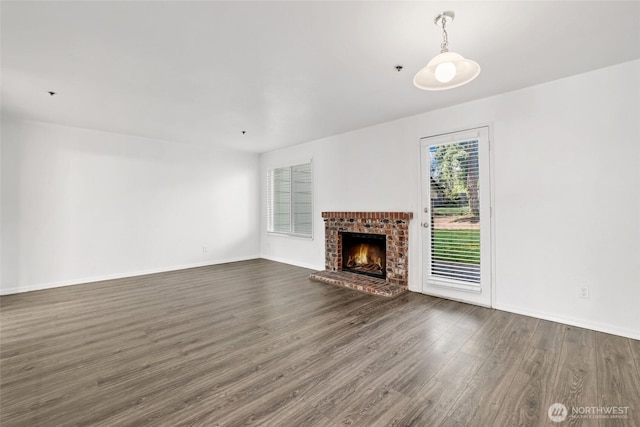 unfurnished living room with baseboards, dark wood finished floors, and a fireplace