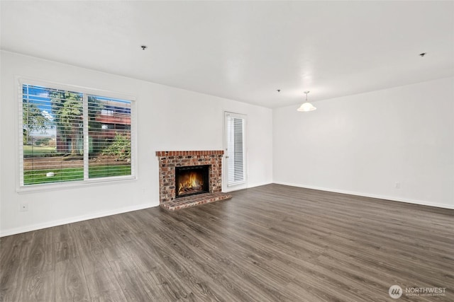 unfurnished living room featuring dark wood-type flooring, a fireplace, and baseboards