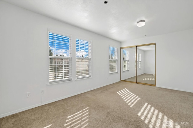 unfurnished bedroom featuring a closet, carpet flooring, and baseboards