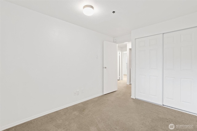 unfurnished bedroom with a closet, baseboards, and carpet flooring