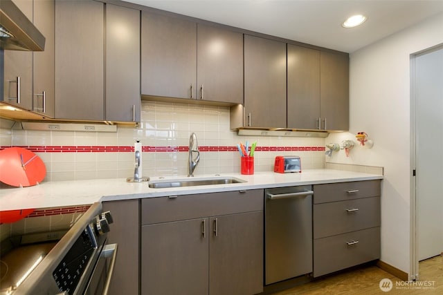 kitchen featuring extractor fan, gray cabinetry, stainless steel appliances, and a sink