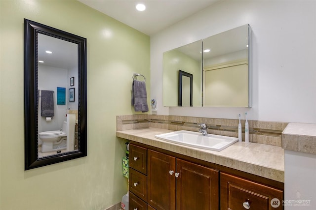 bathroom with recessed lighting, toilet, and vanity