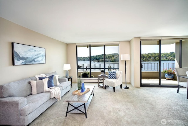 carpeted living area featuring a water view and floor to ceiling windows