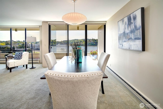 dining room with a water view, baseboard heating, floor to ceiling windows, and carpet