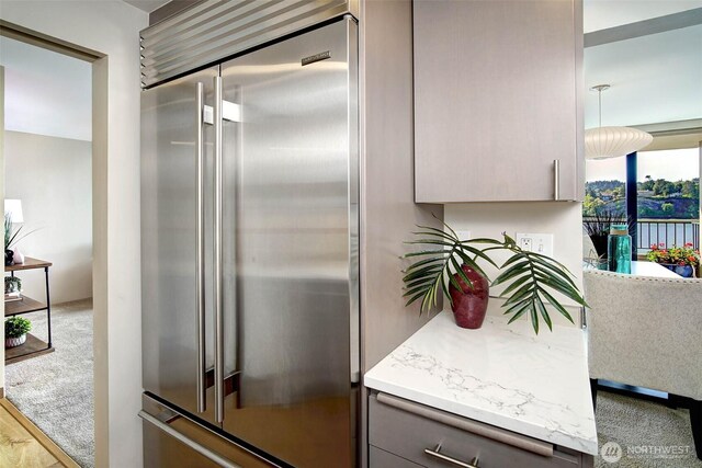 kitchen with gray cabinetry, high end fridge, and light countertops
