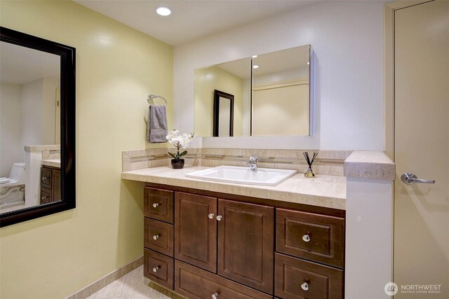 bathroom featuring baseboards, toilet, recessed lighting, tile patterned floors, and vanity