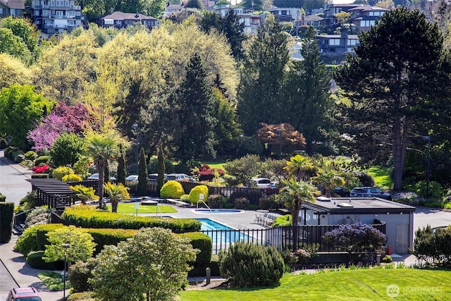 view of community with a pool and fence