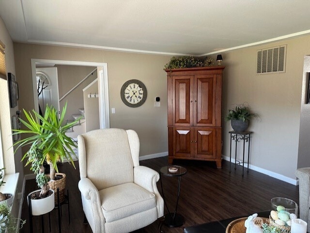 living area featuring dark wood-style floors, visible vents, and baseboards