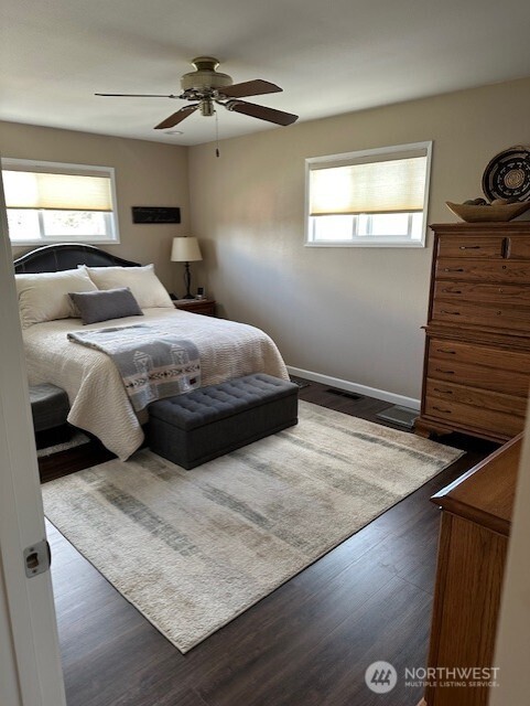 bedroom with baseboards, ceiling fan, and wood finished floors