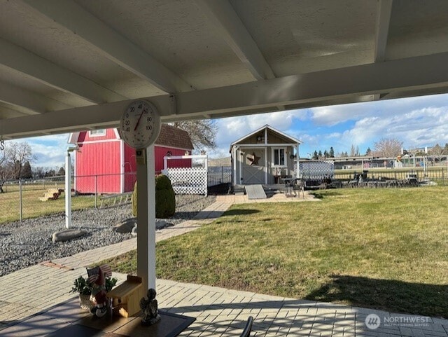 view of yard with a storage unit, an outdoor structure, and fence