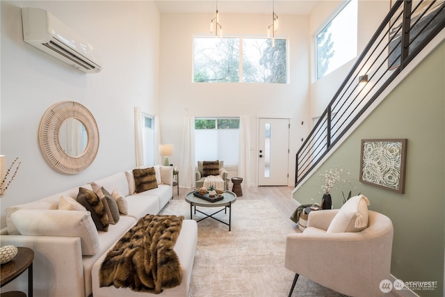 living area featuring a wealth of natural light, stairway, a wall mounted air conditioner, and wood finished floors