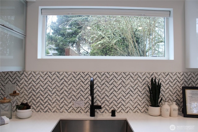 interior space with light countertops, tasteful backsplash, and a sink