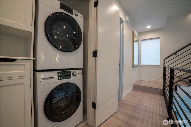 washroom featuring baseboards, laundry area, recessed lighting, stacked washer and clothes dryer, and light wood-style floors