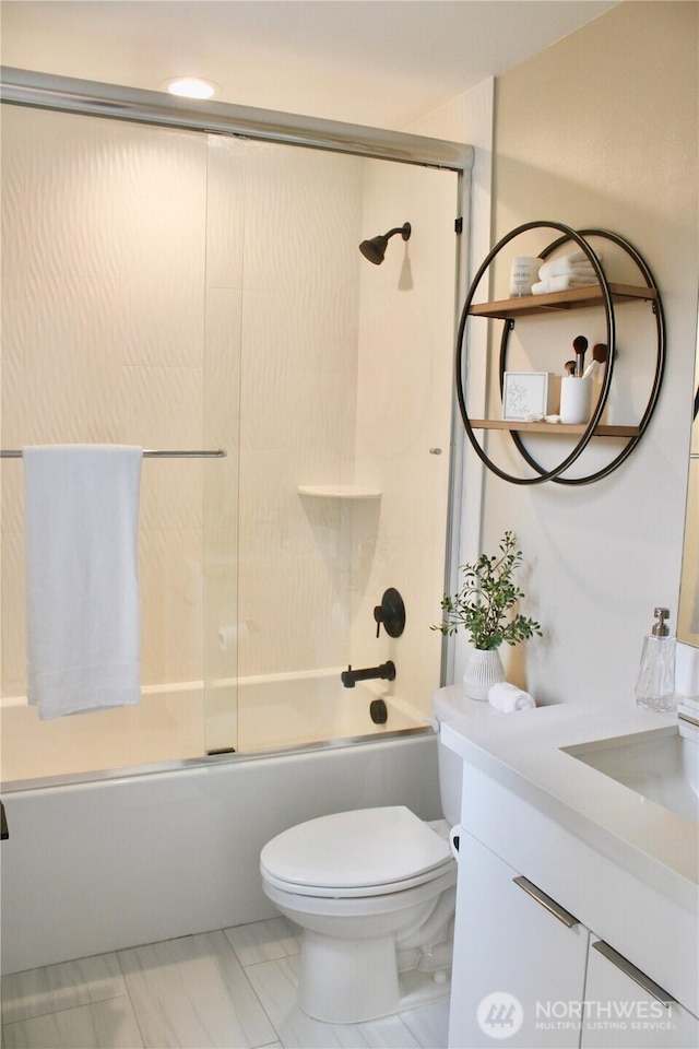 bathroom featuring enclosed tub / shower combo, marble finish floor, toilet, and vanity