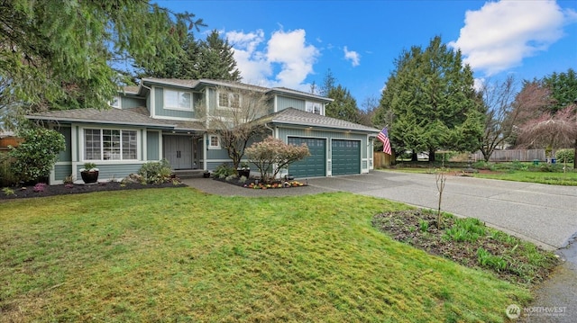 traditional home featuring a front yard, an attached garage, driveway, and fence