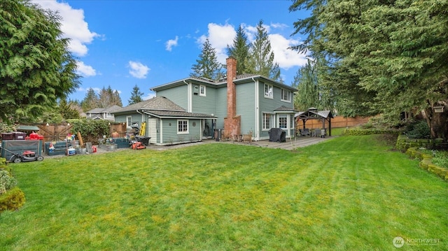 rear view of property featuring fence, a patio area, a lawn, and a chimney