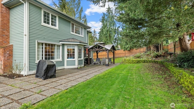 rear view of house featuring a gazebo, a yard, a patio, and fence