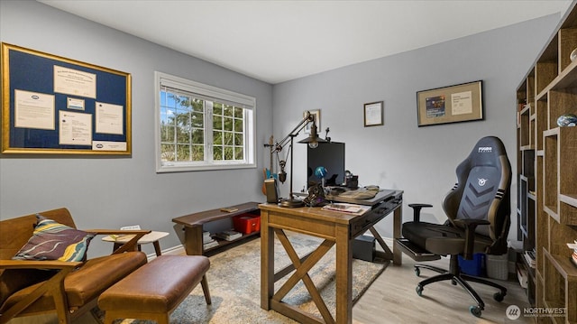 office area featuring light wood-type flooring and baseboards