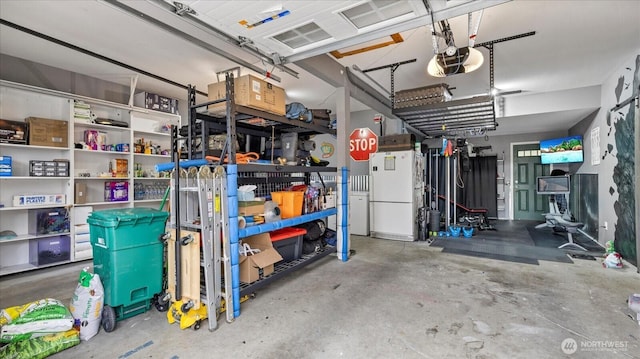 garage with freestanding refrigerator and a garage door opener