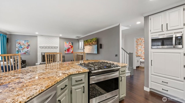 kitchen featuring light stone countertops, dark wood-style flooring, appliances with stainless steel finishes, and ornamental molding