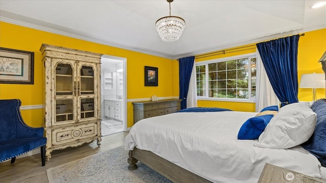 bedroom with a chandelier, ensuite bath, wood finished floors, and crown molding