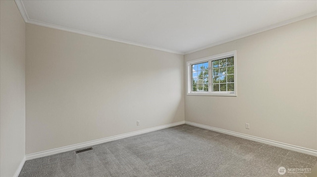 carpeted empty room with visible vents, baseboards, and ornamental molding