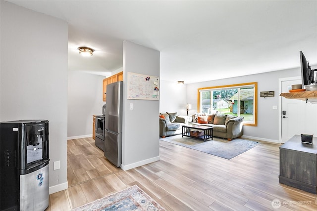 living area featuring baseboards and light wood-type flooring