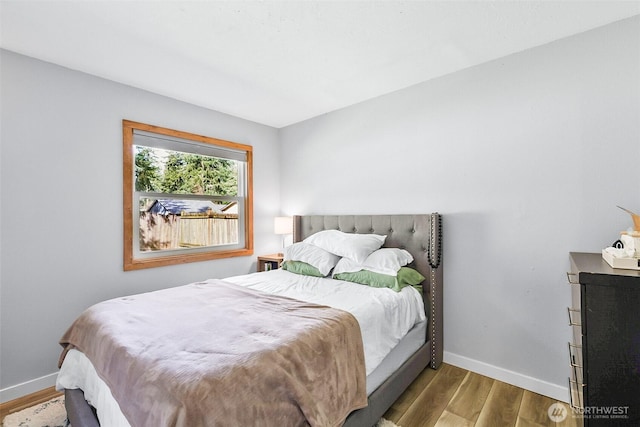 bedroom with wood finished floors and baseboards